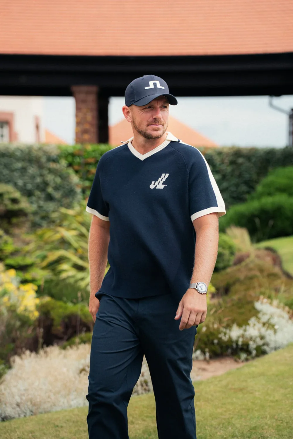 Matt Wallace in a navy J.Lindeberg polo with white trim and navy trousers.