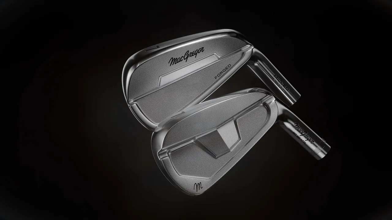 Two MacGregor irons, one showing its face and one its cavity back, on a black background.