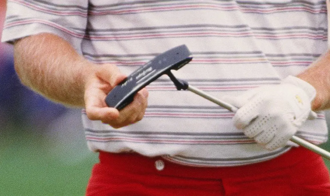 Jack Nicklaus in a striped shirt and red trousers holding an oversized MacGregor Response putter.