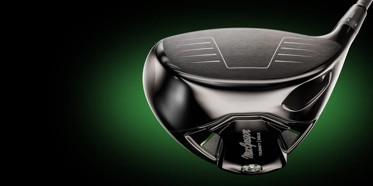 The sole of a black MacGregor Tourney MAX driver lit green against a dark background.