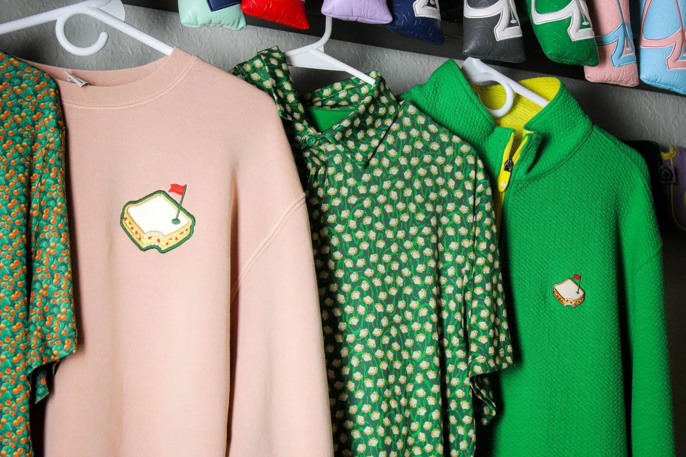Pins & Aces polos and headcovers on a rack at the Arvada facility