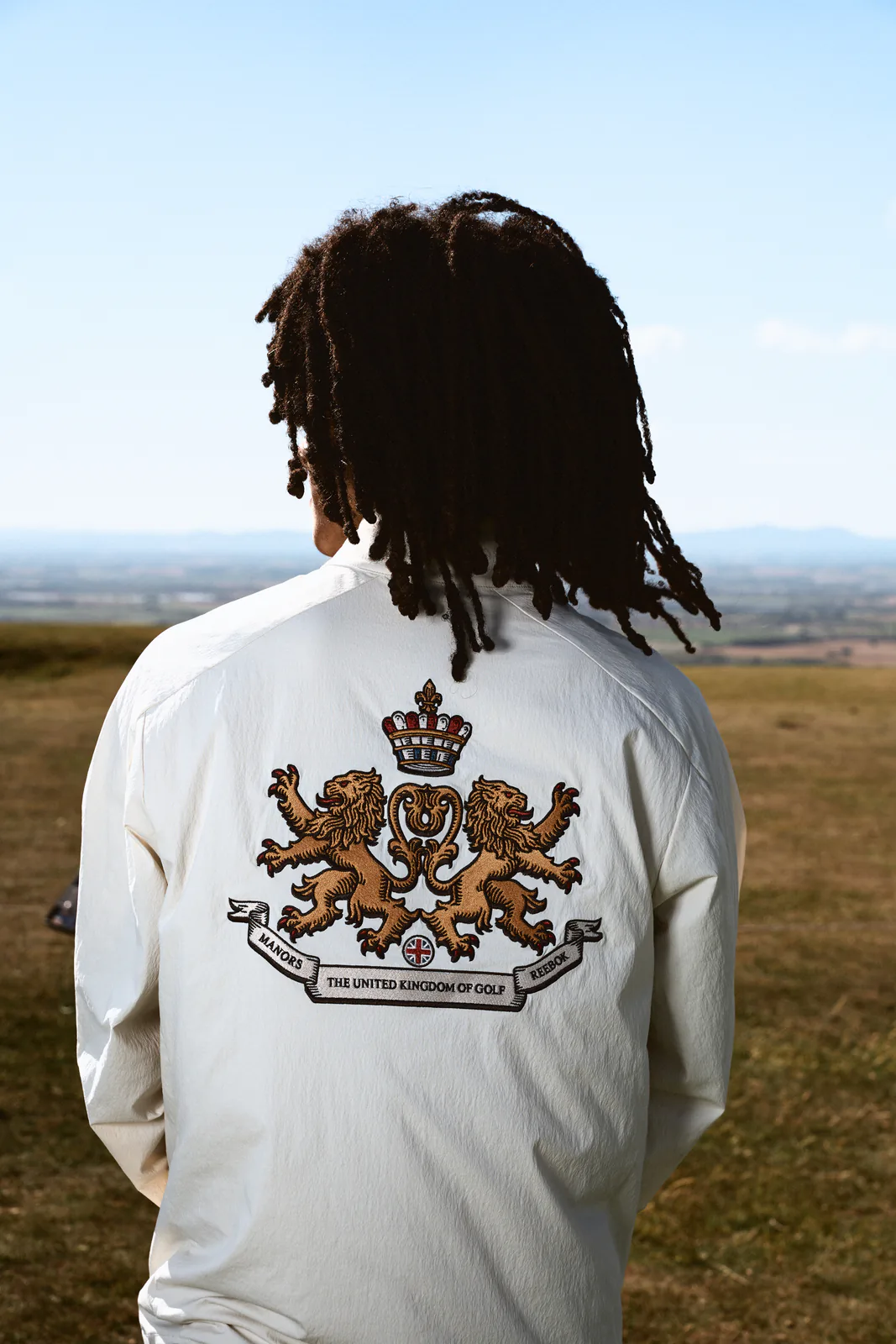 Back view of the Reebok x MANORS Harrington Jacket showing a crest with two lions and a crown above United Kingdom of Golf lettering.