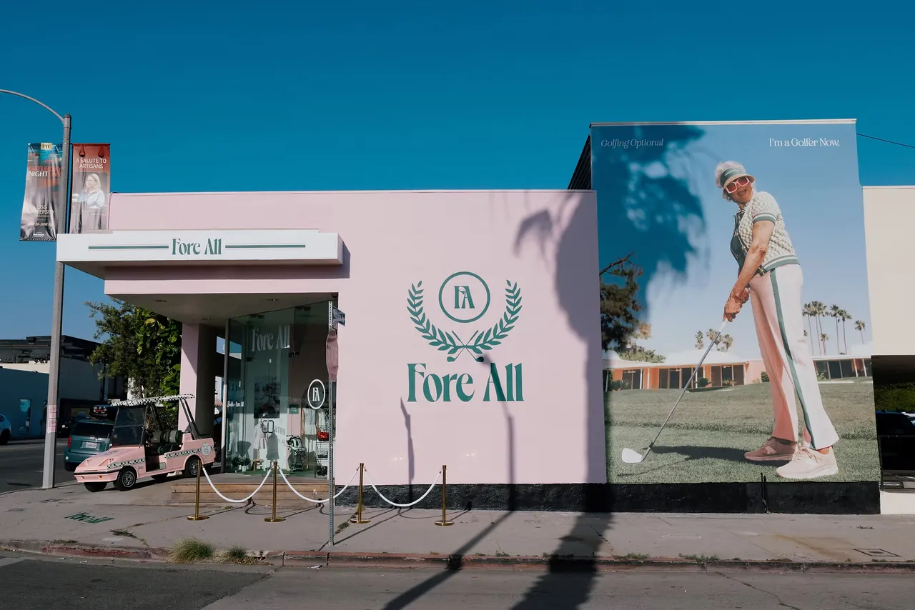 A pink Fore All storefront with a large mural of a golfer on its side wall.