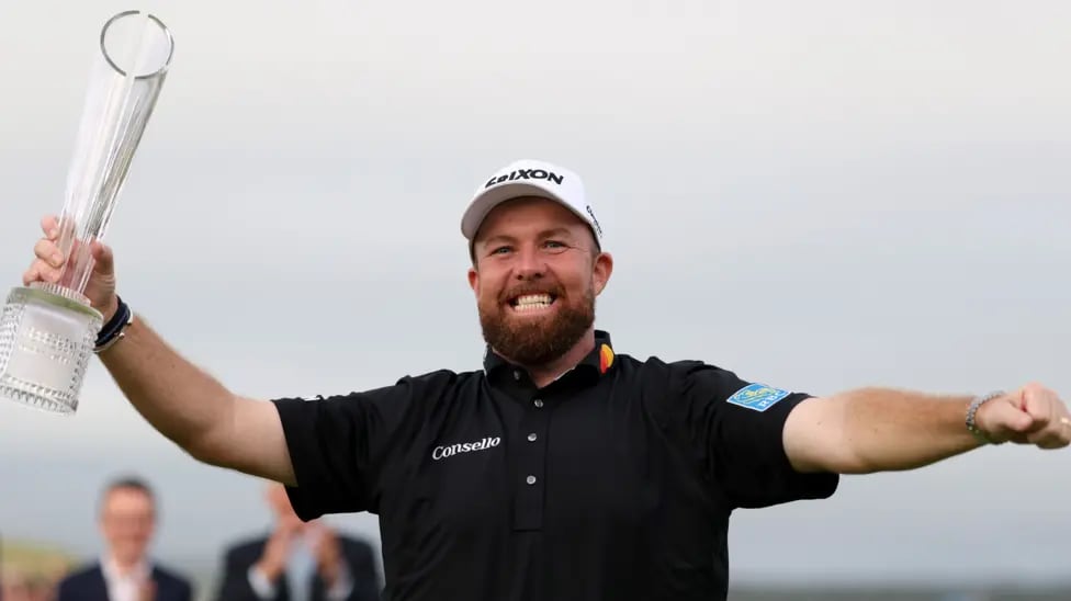 Shane Lowry in a Srixon cap holding the Irish Open trophy aloft